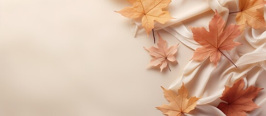 Autumn composition with maple leaves and beige fabric on a isolated pastel background Copy space Minimalist style top view