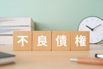 不良債権と書かれたブロックが置かれたデスク