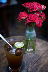 Classic Dracontomelon juice on a wooden table decorated with roses