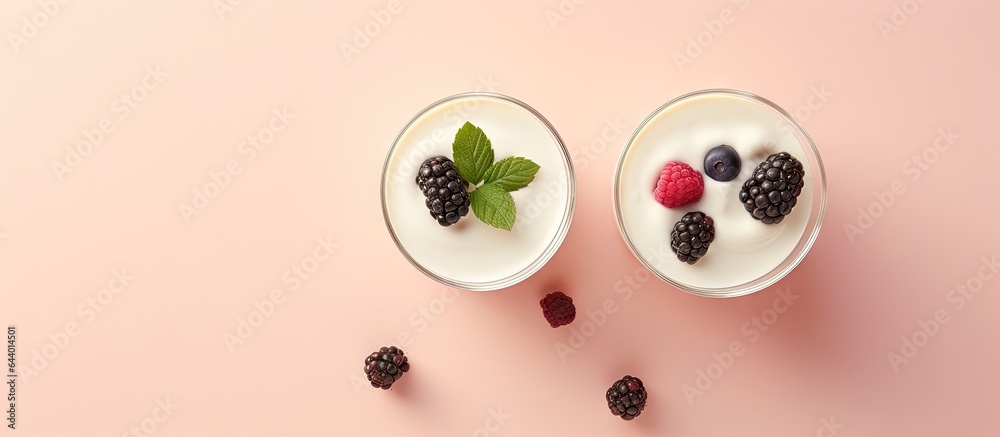 Poster front view of macro shot of wild berry topped white yogurt in two glasses on a isolated pastel backg