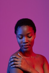 African american woman with short hair, looking down with hand on shoulder, purple copy space