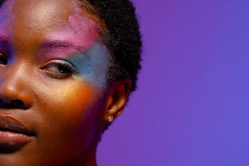 Half portrait of african american woman with short hair, colourful make up, copy space