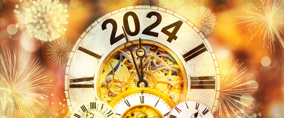2024 New Year with clock counting down to midnight with defocused golden background and fireworks