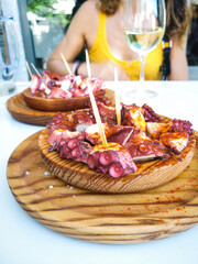 Delicious wooden plates of galician style cooked octopus with paprika and olive oil. Pulpo a la gallega