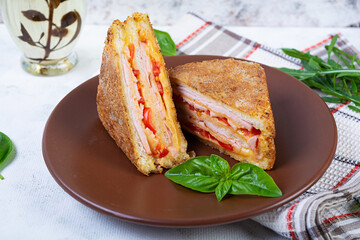 Sandwiches fried in breadcrumbs with ham, cheese and tomatoes