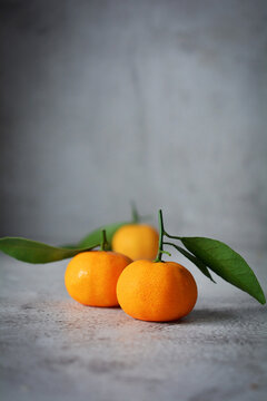 two fresh orange fruits with leaves. mandarin orange on grey and texture background 