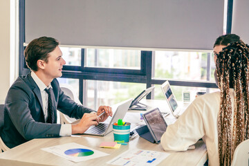 Business analyst team using laptop for financial insight with Fintech paper for data analysis dashboard. Creative and analytic brainstorming for marketing plan strategy system idea. Prodigy teamwork