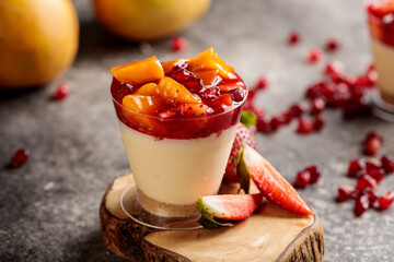 fruit cheesecake with strawberry, mango, pineapple and pomegranate seeds served in cup isolated on...