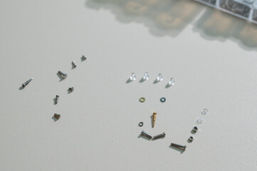 Bolts for repairing eyeglass frames on a white background.