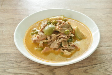 spicy boiled slice pork meat with eggplant in coconut milk green curry soup on plate