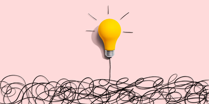 Clarifying complex ideas theme with light bulb - Flat lay