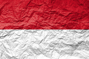 Flag of Monaco on crumpled paper. Textured background.