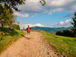 Millennial man hiking with backpack Carpathian Mountains road climbing peak scenic view. Travel Lifestyle wanderlust adventure vacations Bearded guy walking outdoor alone into the wild Ukraine, Europe
