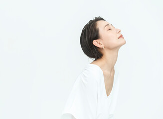 美しい女性の横顔//目を閉じ顎を上げている/白背景スタジオ撮影