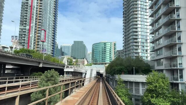 blue line skytrain front the whole process with people on the train railroad view trees summer train view big city life BC, Vancouver, Canada