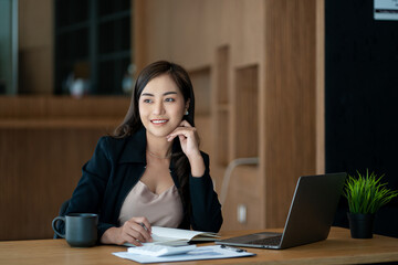 Asian woman working with financial documents and laptop in office, financial accounting concept