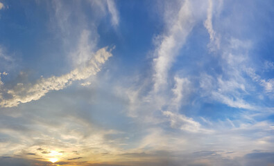 Naklejka na ściany i meble Cloudy sky. White cloud, blue sky and yellow sunlight, sunset nature background