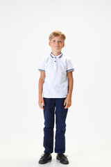 Full-length portrait of boy, child wearing smart casual clothes for school, standing against white studio background. Concept of childhood, school, education, fashion, style. Copy space for ad