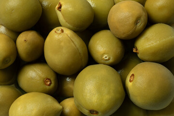 Whole homemade pickled unripe green almonds full frame close up as background