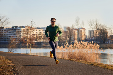 Adult man running in urban environment during autumn or winter