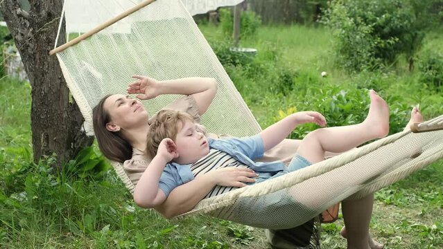 tender moment unfolds as a loving mother and her 5-year-old son engage in heartwarming dialogue, all while nestled in a hammock on a balmy summer day