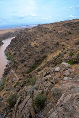 Wooden railing stairs descending from cliff to river