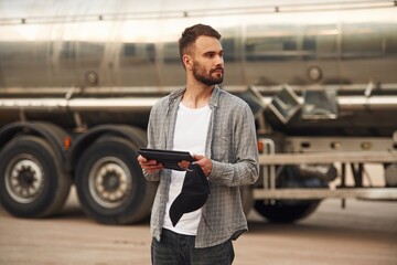 Big fuel tanker. Young truck driver in casual clothes