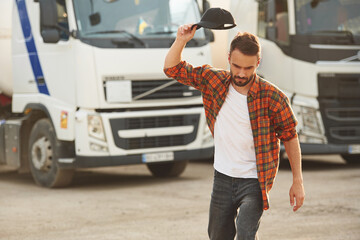 Fototapeta na wymiar Angry, throwing the cap. Young truck driver in casual clothes