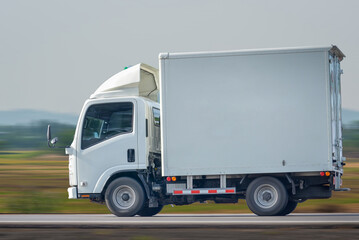 Small truck driving on the highway, Small white delivery truck moving fast on road, distribution business express delivery service