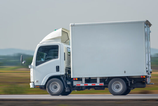 Small Truck Driving On The Highway, Small White Delivery Truck Moving Fast On Road, Distribution Business Express Delivery Service