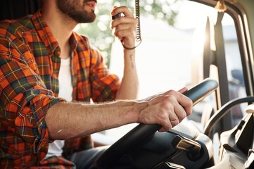 Radio communication. Young truck driver in casual clothes