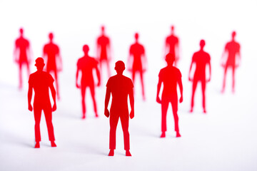 Group of red paper cut-out male figures. Concept of paper cut people with blurred background.