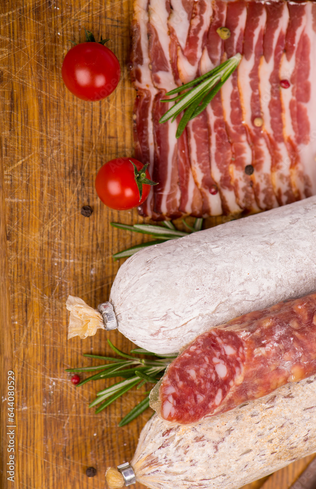 Wall mural Smoked sausage with rosemary and peppercorns tomatoes and garlic