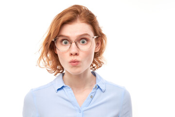 Fototapeta premium Portrait of surprised young woman with bulging eyes shocked by news, shyly looking at camera isolated over white studio background.