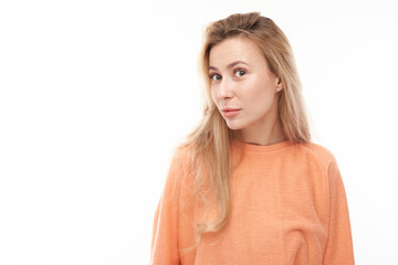Portrait of young blond girl suspiciously looking at camera isolated on white studio background,...