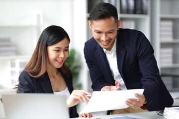 Boss and secretary working on documents together in office. Businessman and colleagues discussing in office collaboration.