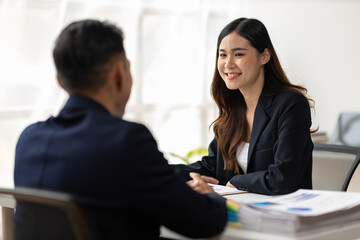 Boss and secretary working on documents together in office. Businessman and colleagues discussing in office collaboration.