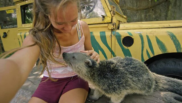 Woman taking a selfie with a binturong