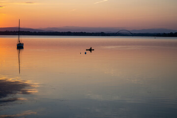 Kayak and sailboat at sunrise on Lake Champlain