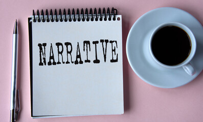 NARRATIVE - word in a white notebook on the background of a cup of coffee, a pen