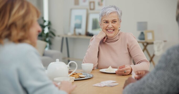 Tea, happy and retirement with friends and playing cards in living room for relax, diversity and poker. Games, smile and community with group of old people in nursing home for party and celebration