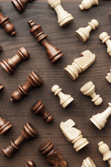 Wooden chess figures on the brown table. Black and white chess figures on wooden background.