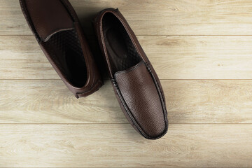 Brown leather elegant shoes on wooden table
