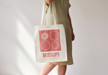 Fototapeta na wymiar Mockup of woman carrying customizable tote bag, side view mid section