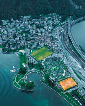Aerial view of a football field in Melide, a small town along the Lugano Lake at sunset in Ticino, Switzerland.