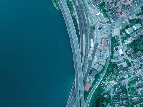 Aerial view of a road and a railway following the Lugano Lake coastline in Melide, Ticino, Switzerland.