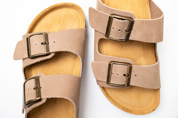 Leather beige sandals birkenstocks on white background top view flat lay. Unisex summer shoes, genuine leather flip flops with cork soles. Stylish fashion footwear, mockup for design