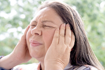 Fototapeta premium close-up of mature charismatic woman 50 years holding hand over eye, eye pain treated medical emergency, ocular ache, sharp sensation, foreign body sensation, vision changes or severe discomfort