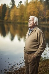Fototapeta premium a handsome senior man standing beside a lake in the woods