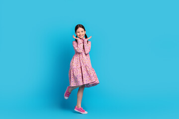 Full body photo of funky beautiful little kid school girl posing hands cheeks wear stylish dress funky isolated on blue color background